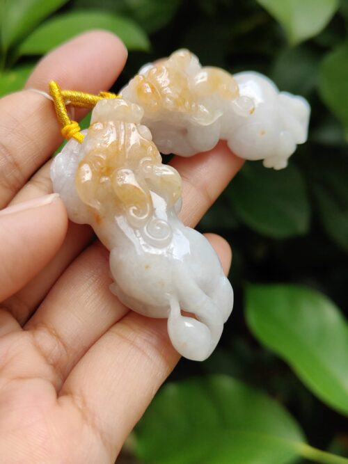 Una mano sosteniendo un colgante de jade.