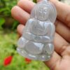 a hand holding a jade pendant