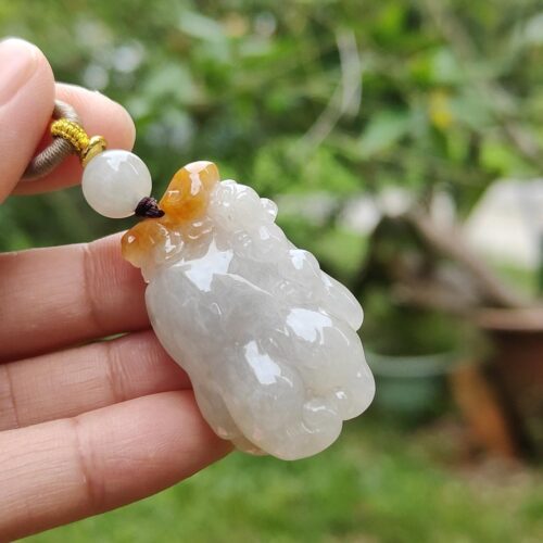 一只手拿着白玉吊坠