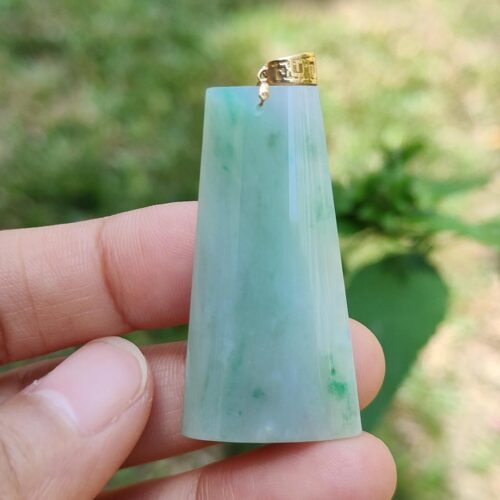 Una mano sosteniendo un colgante de jade.
