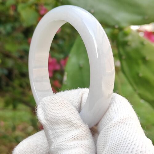 a hand in glove holding a white ring