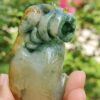 a hand holding a jade sculpture