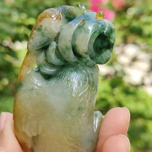 a hand holding a jade sculpture