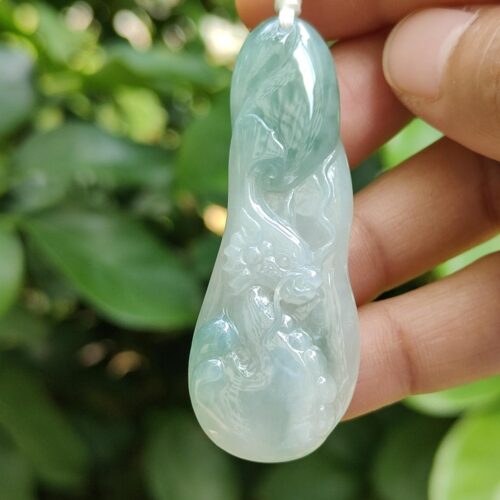 a hand holding a jade pendant