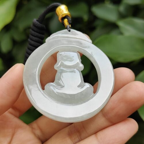 a hand holding a jade pendant