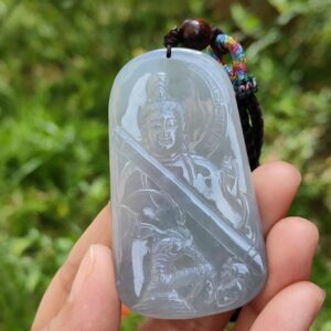 Una mano sosteniendo un colgante de jade.