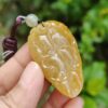Una mano sosteniendo un colgante de jade.