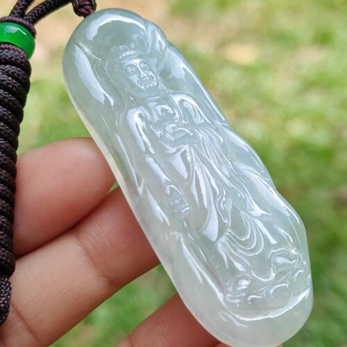 a hand holding a jade pendant