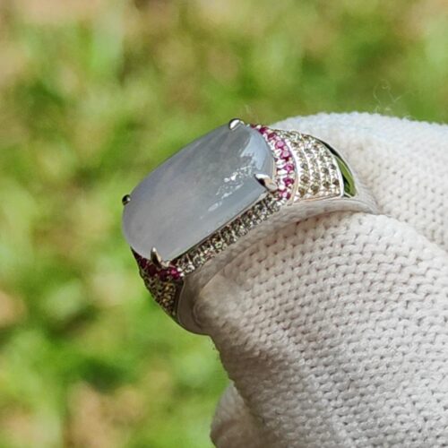 a hand wearing a white glove with a large stone ring