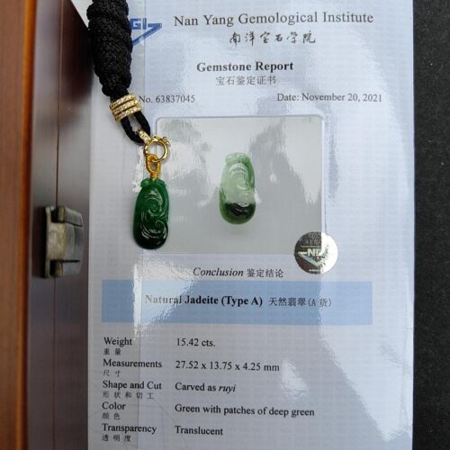 a green jade pendants on a black cord