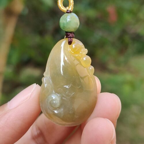 Una mano sosteniendo un colgante de jade.