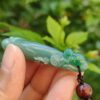 Una mano sosteniendo un colgante de jade.