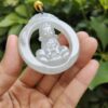 a hand holding a jade pendant