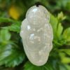 a white jade pendant from a green plant