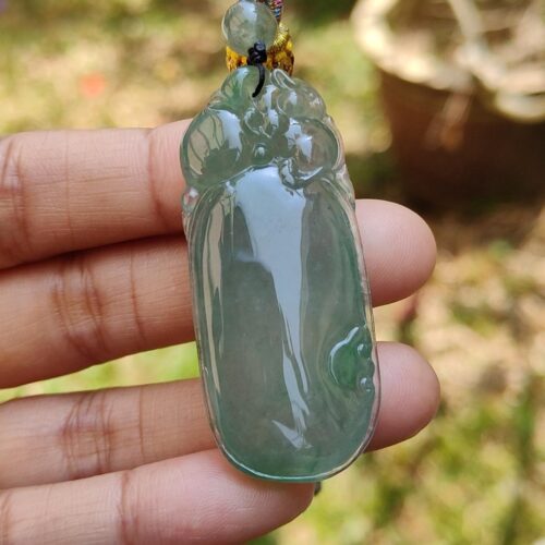 Una mano sosteniendo un colgante de jade.