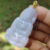 a hand holding a jade pendant