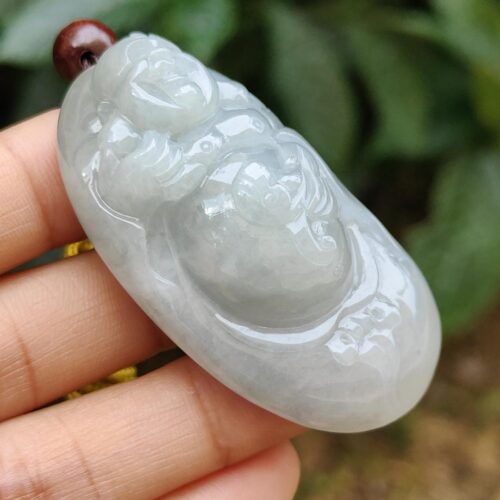 a hand holding a jade pendant