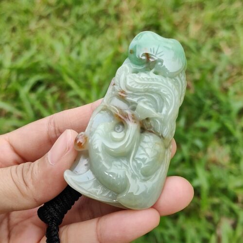 a hand holding a jade figurine