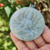 Una mano sosteniendo un colgante de jade.
