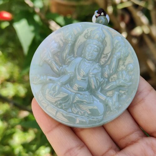 Una mano sosteniendo un colgante de jade.