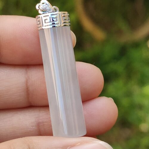 a hand holding a white crystal pendant