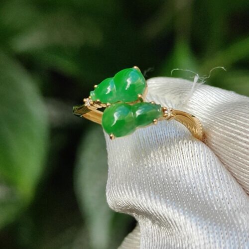a gold ring with green stones on it