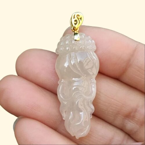 Una mano sosteniendo un colgante de jade.