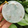 a hand holding a jade pendant