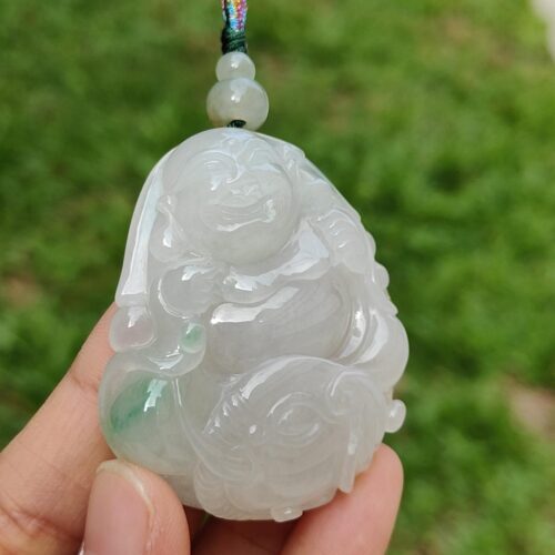 a hand holding a jade pendant