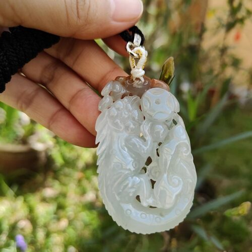 tangan memegang liontin giok