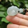 a hand holding a jade bead