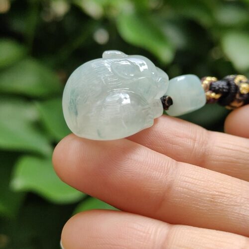 a hand holding a jade bead