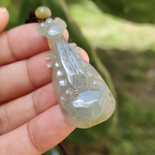 翡翠のペンダントを持つ手