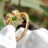 a gold ring with a green stone in it