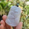a hand holding a carved stone