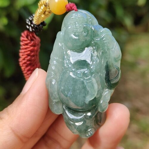 a hand holding a jade pendant
