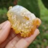 a hand holding a piece of yellow and white stone