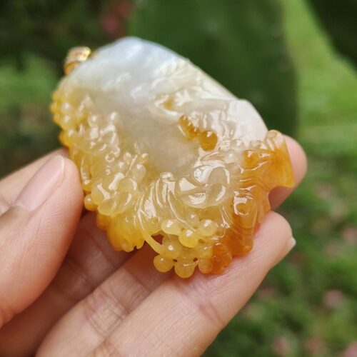a hand holding a piece of yellow and white stone