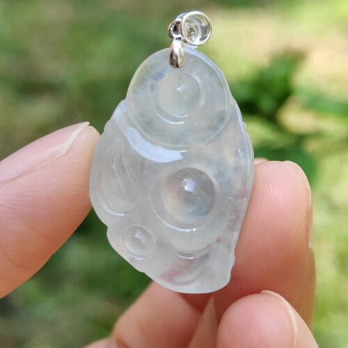 一只手拿着白玉吊坠