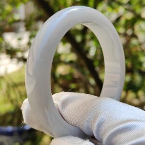 una mano sosteniendo un anillo blanco