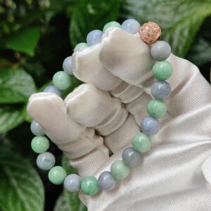 a hand in a glove holding a bracelet