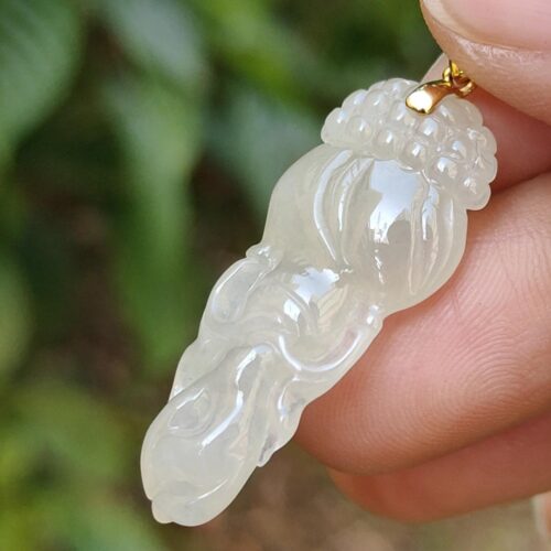 Una mano sosteniendo un colgante de jade.
