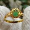 a hand wearing a gloved hand holding a gold ring