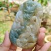 a hand holding a jade pendant