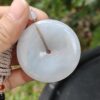 a hand holding a white round object