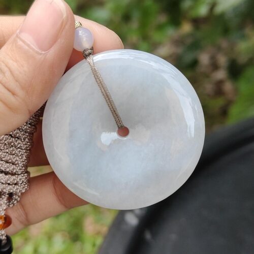 a hand holding a white round object