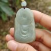 Una mano sosteniendo un colgante de jade.