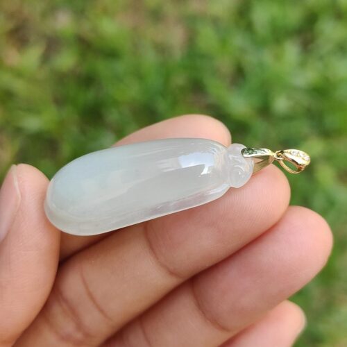 Una mano sosteniendo un colgante de jade.