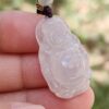 a hand holding a jade pendant