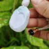 a hand holding a jade necklace